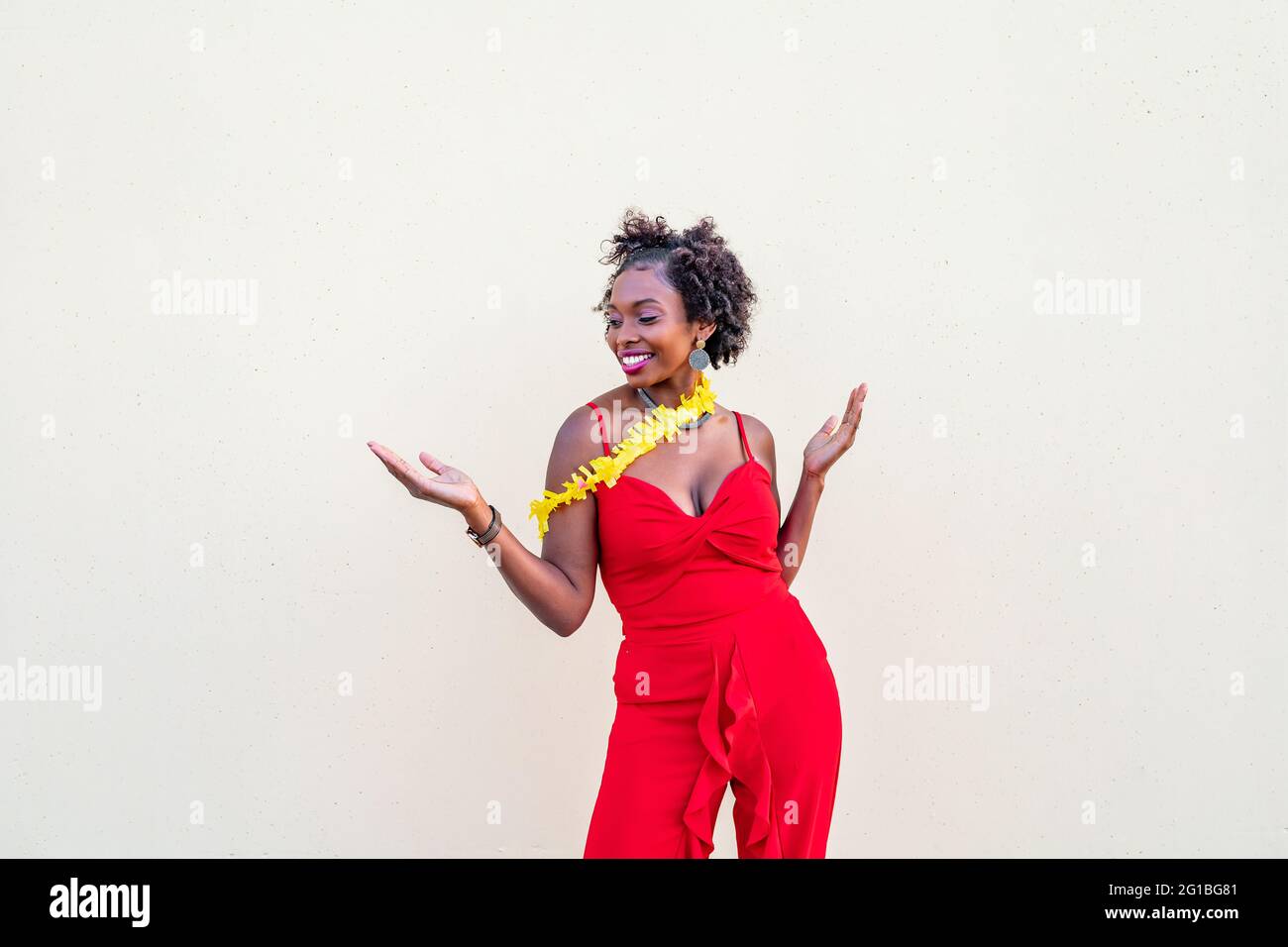 Femme afro-américaine aux bras étirés et à la bouche ouverte debout sur fond blanc Banque D'Images