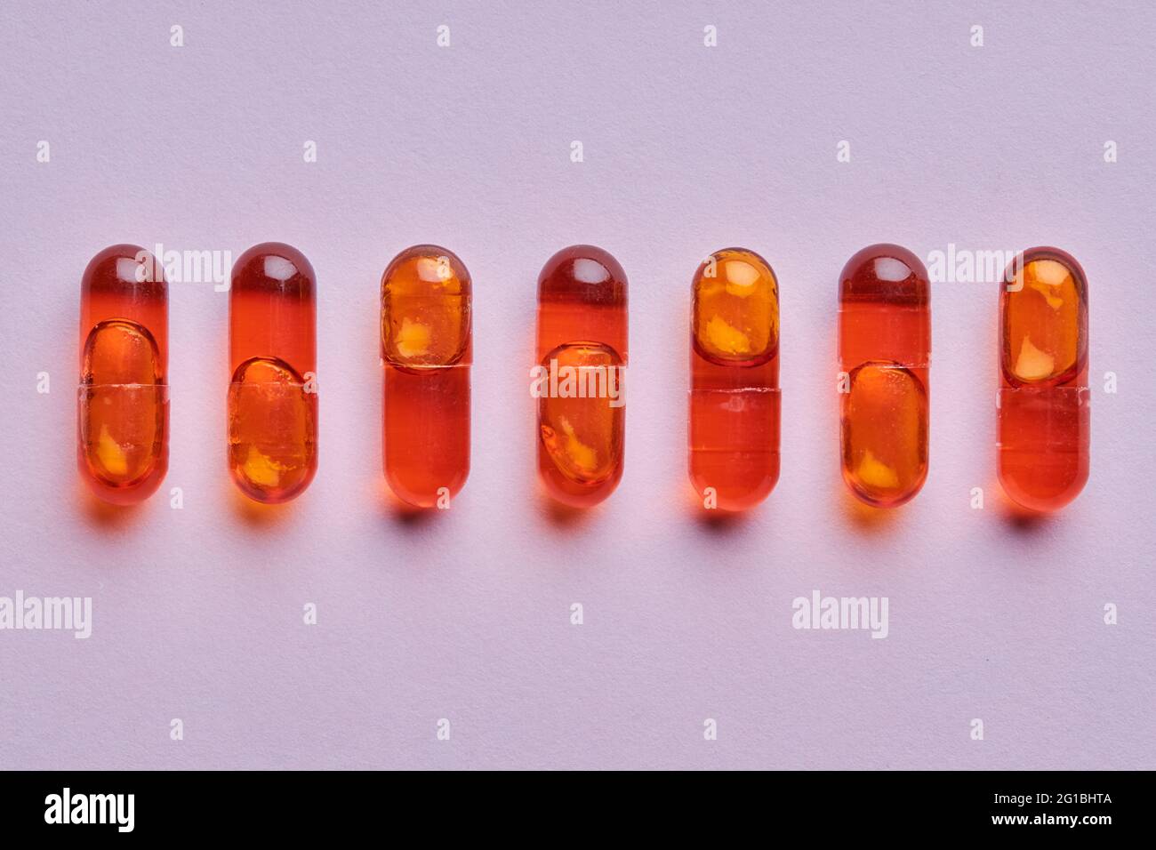 Vue de dessus composition de pilules orange sur fond rose en studio léger Banque D'Images