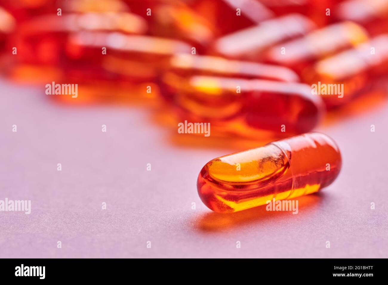 Composition de pilules d'orange dispersées sur fond rose en studio léger Banque D'Images