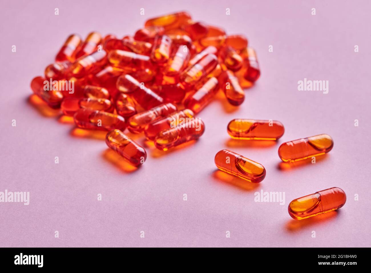 Composition de pilules d'orange dispersées sur fond rose en studio léger Banque D'Images