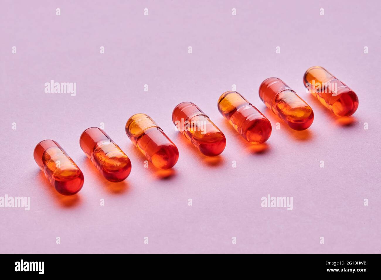 Vue de dessus composition de pilules orange sur fond rose en studio léger Banque D'Images