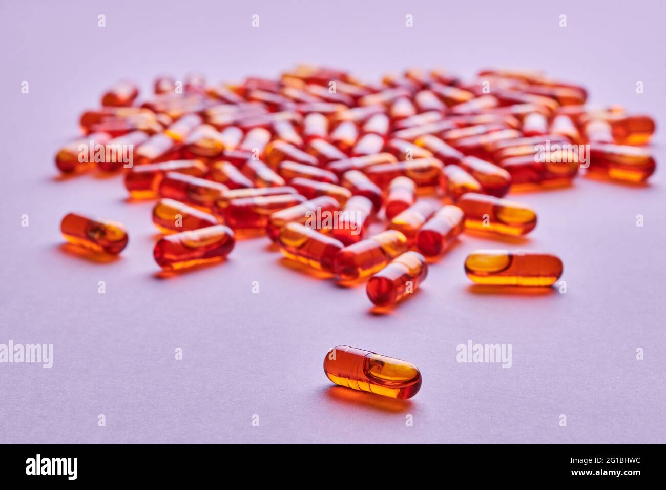 Composition de pilules d'orange dispersées sur fond rose en studio léger Banque D'Images