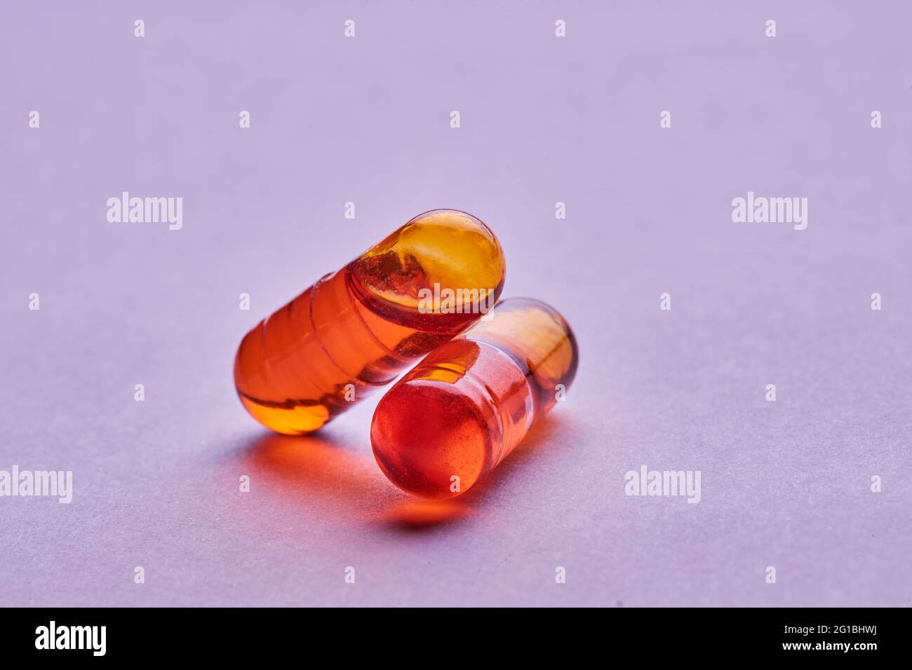 Composition de pilules orange sur fond rose en studio léger Banque D'Images