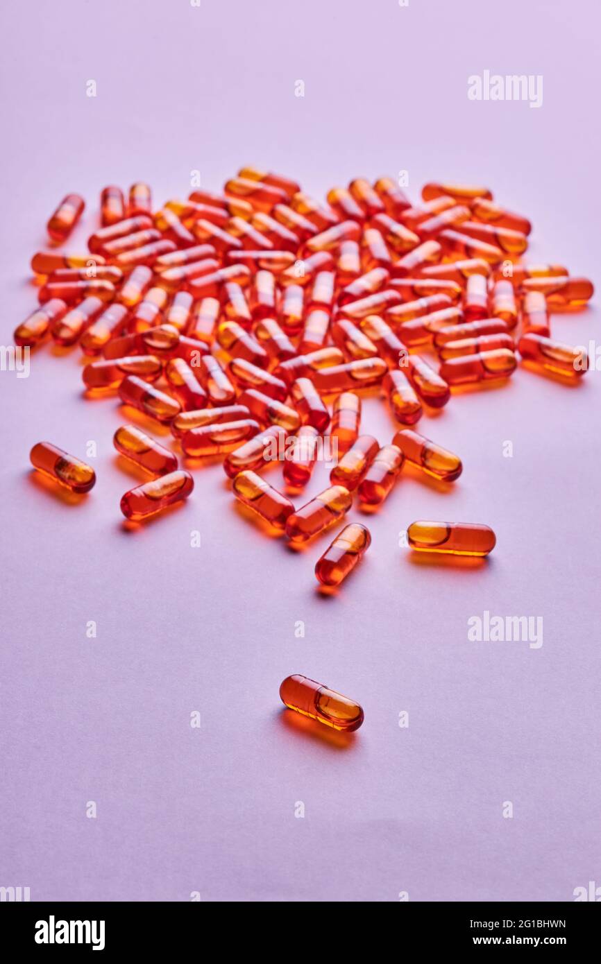 Composition de pilules d'orange dispersées sur fond rose en studio léger Banque D'Images