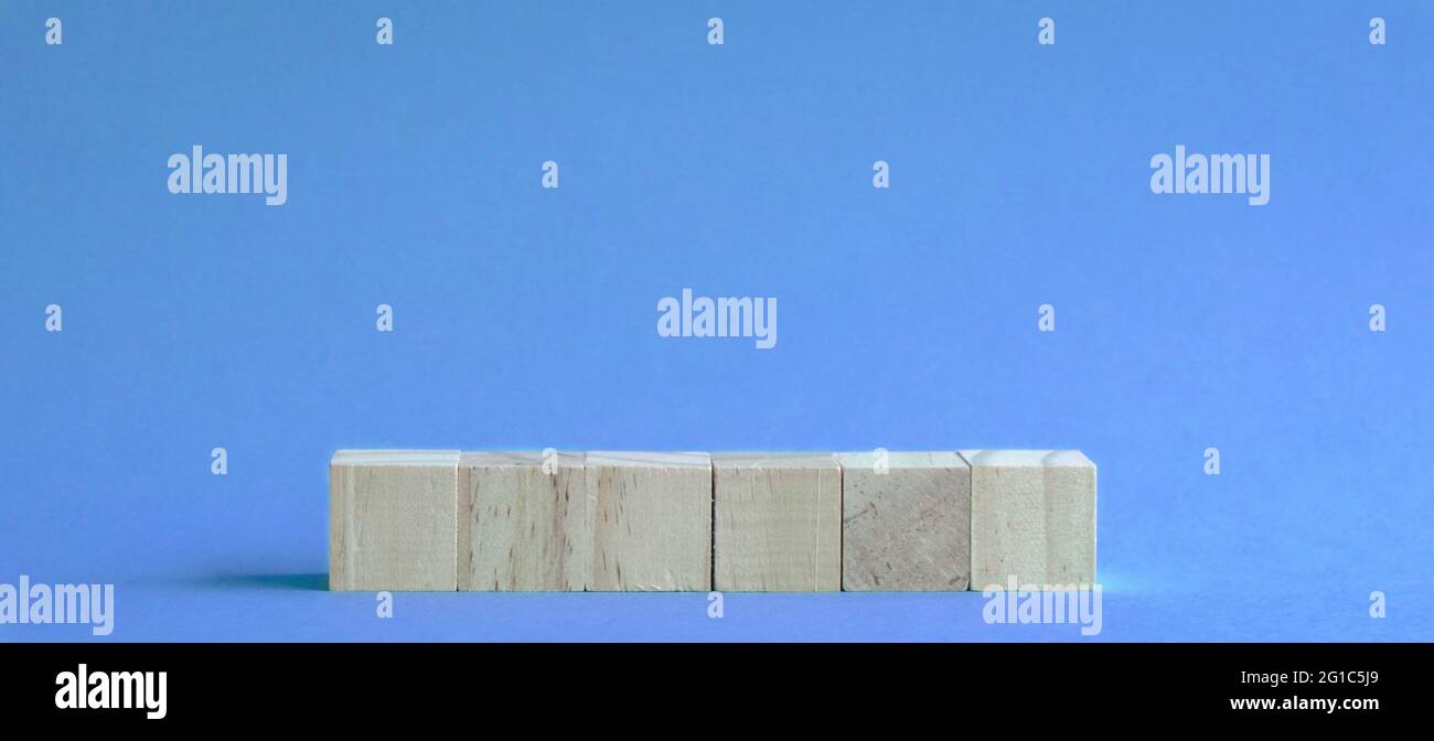 6 lettres vierges et blocs de bois sur la table avec fond bleu. Banque D'Images