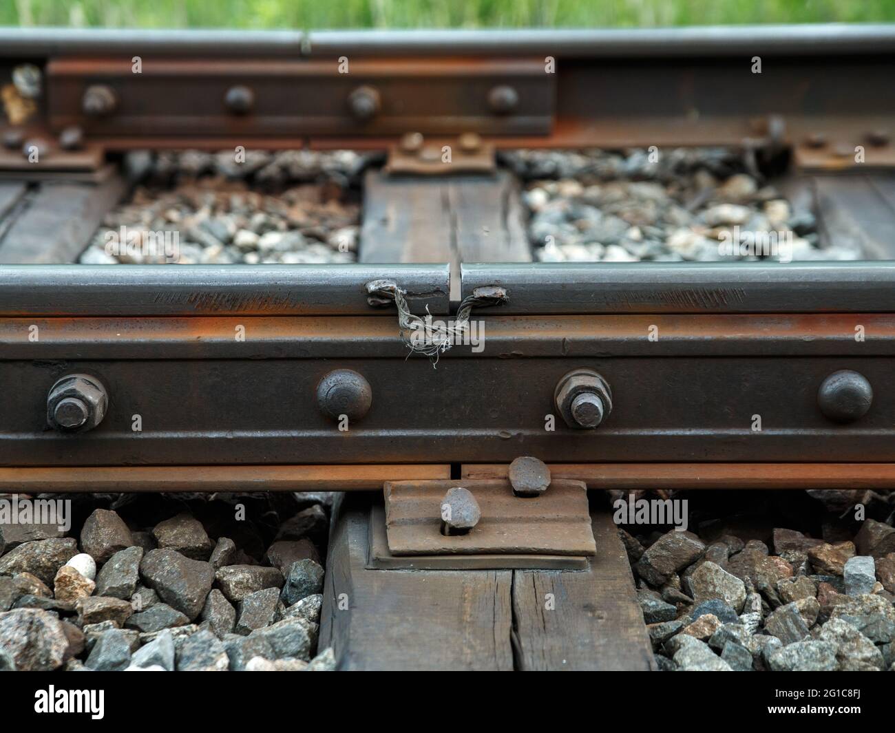 Vieux rails rouillés sur des traverses en bois et de grandes pierres entre eux. Banque D'Images