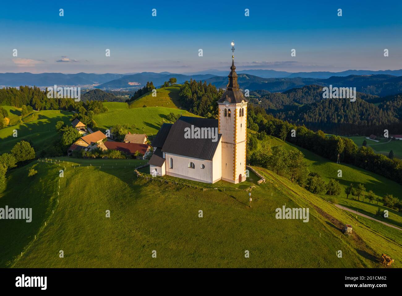 Sveti Andrej, Slovénie - vue aérienne par drone de l'église Saint Andrew (SV. Andrej) au coucher du soleil dans la région de Skofja Loka. Heure d'été dans les alpes slovènes avec c Banque D'Images