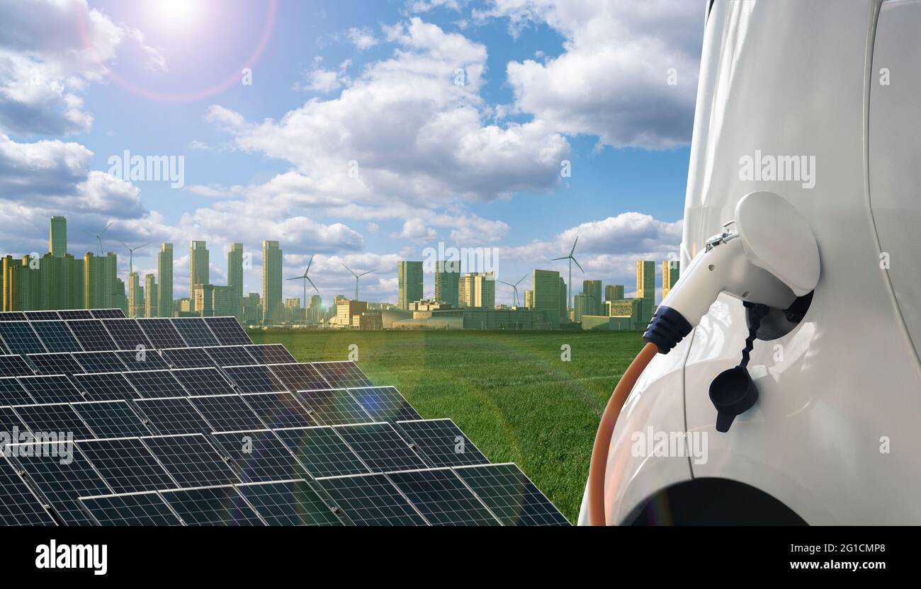 Gros plan de la voiture électrique avec un câble de charge connecté sur le fond de la ville écologique Banque D'Images