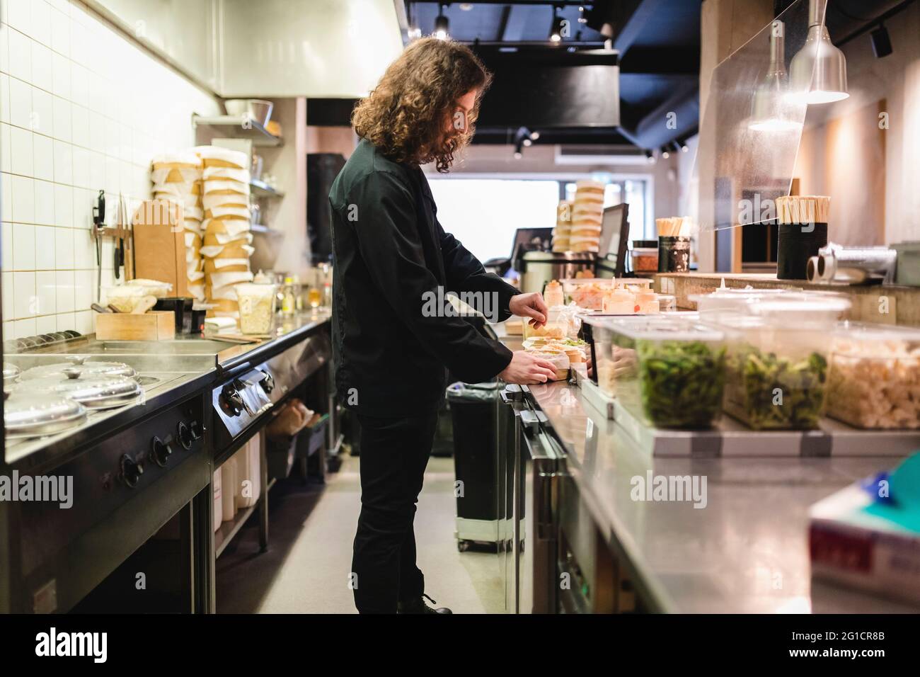 Un jeune chef cuisinier prépare des plats au restaurant Banque D'Images