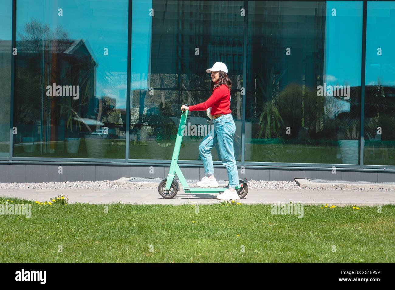 jeune femme à cheval électrique kick scooter copier l'espace printemps ensoleillé jour Banque D'Images