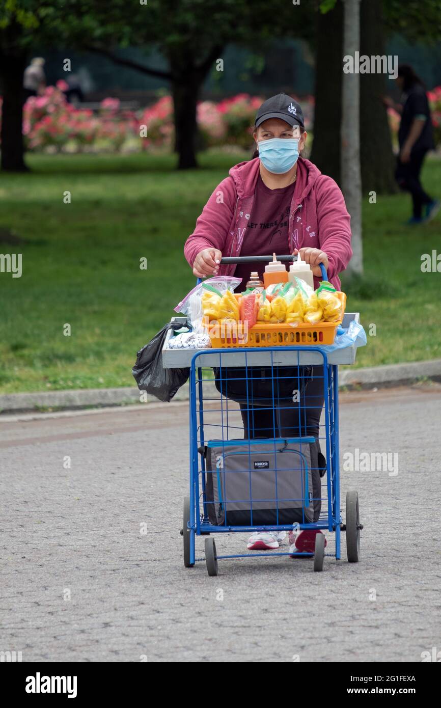 Une femme d'âge moyen, probablement sud-américaine, qui vend des tranches de mangue dans le parc Flushing Meadows Corona, à Queens, dans la ville de New York. Banque D'Images