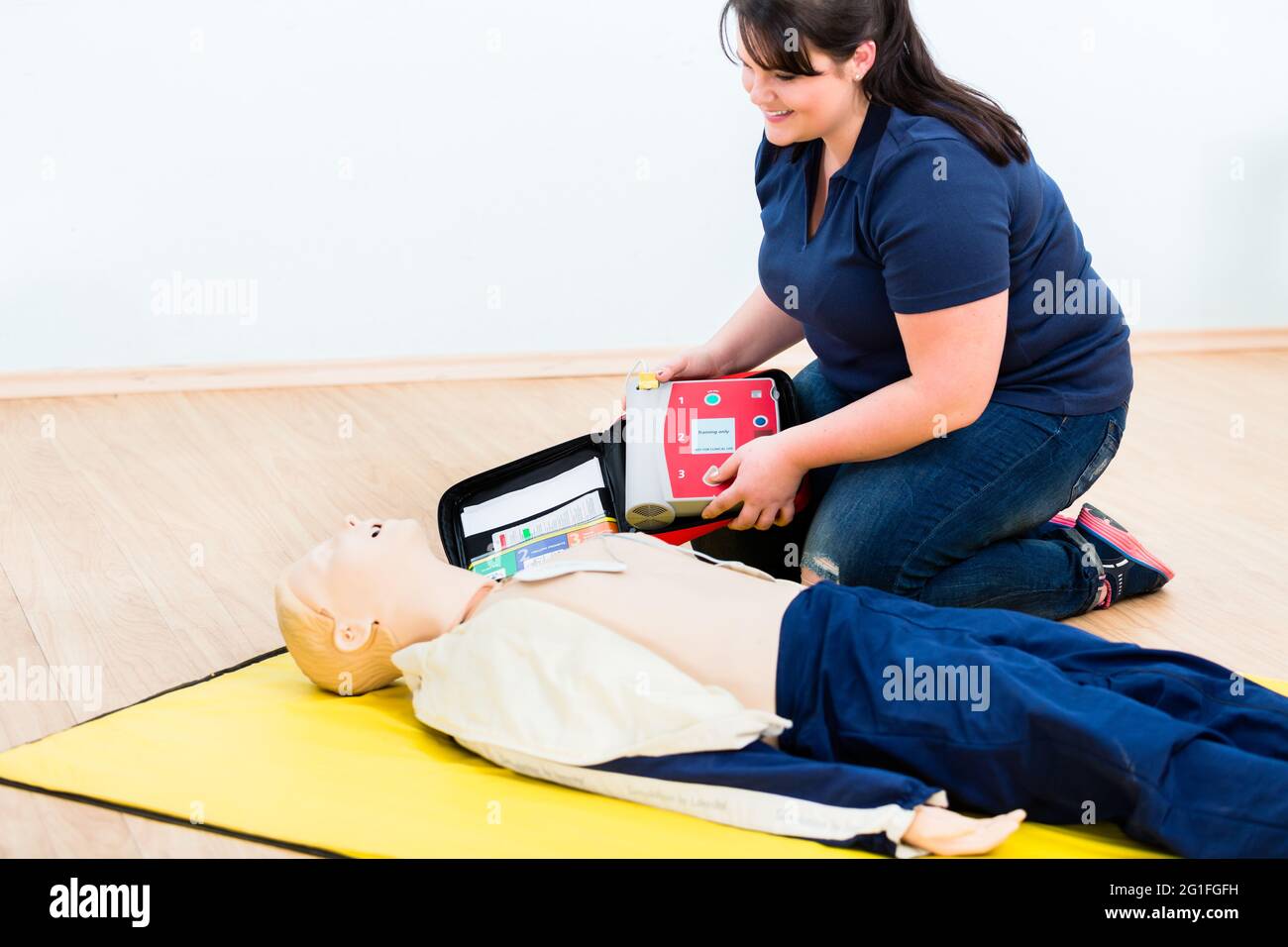 Le secouriste réapprend l'apprentissage avec un défibrillateur dans le cadre d'une formation de premiers secours Banque D'Images