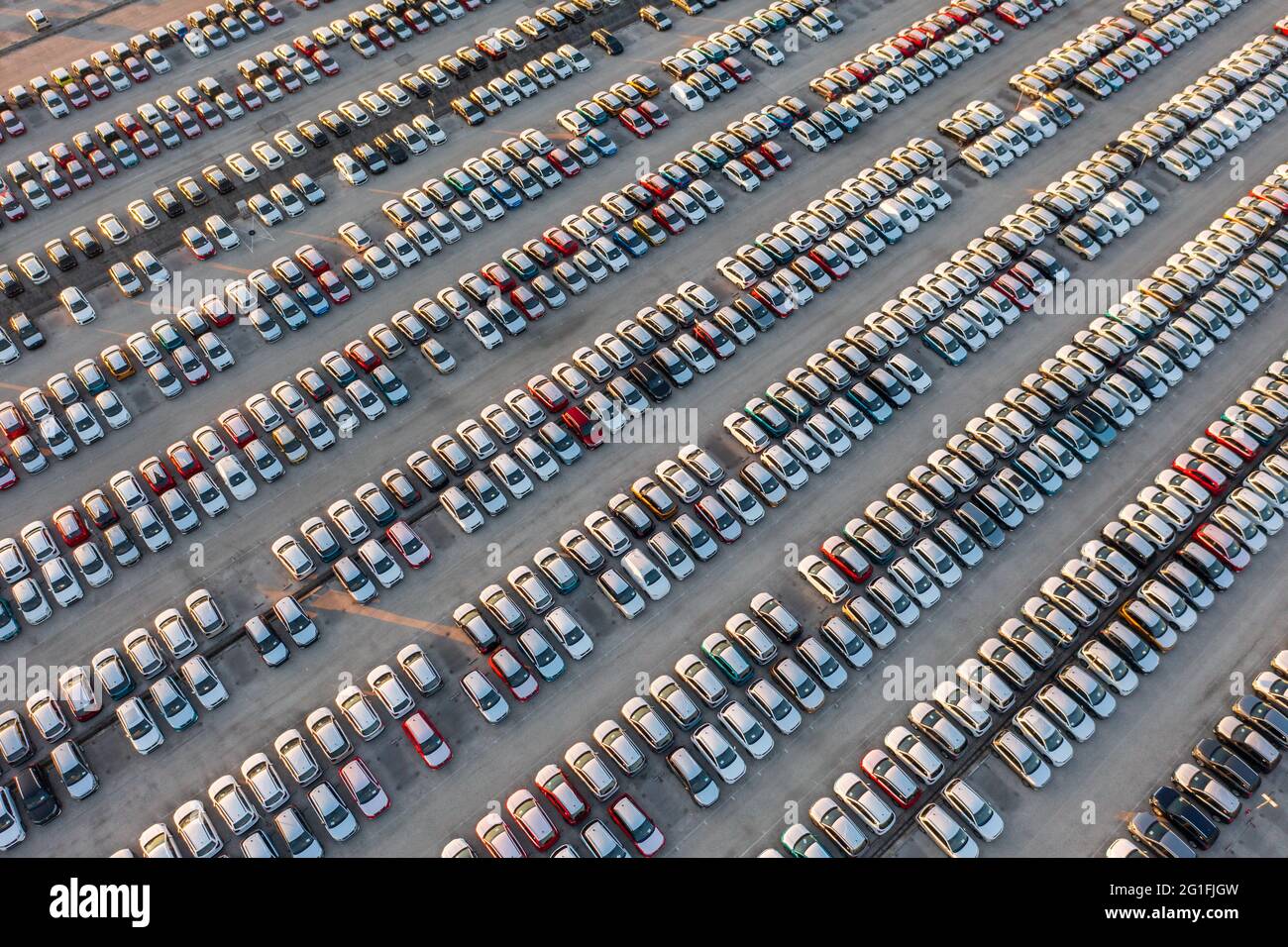 Vue aérienne de dessus vers le bas des voitures neuves au centre logistique, près de l'usine. Prêt à exporter ou importer. Parking. Banque D'Images