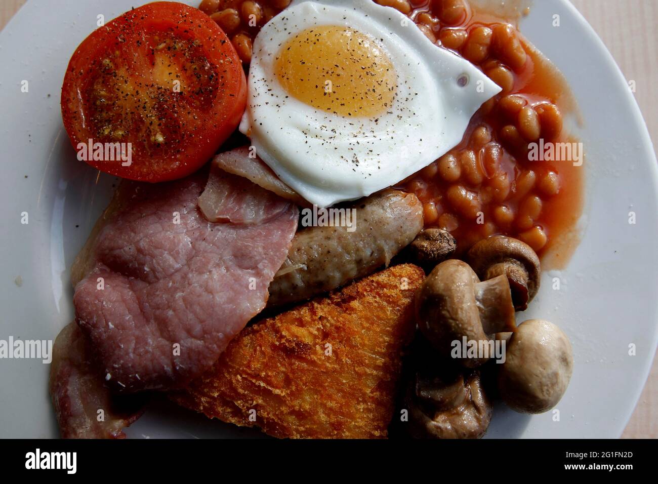 Petit déjeuner anglais, petit déjeuner anglais complet, saucisses, miroirs, œufs frits côté ensoleillé vers le haut, bacon, bacon, tomates frites, haricots, grains de café Banque D'Images