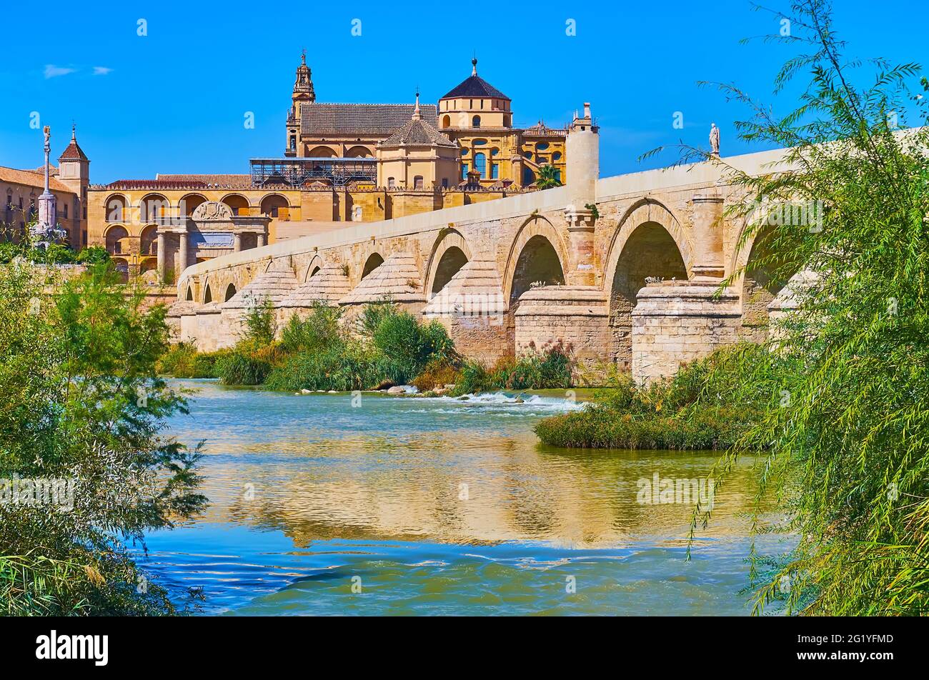 Le bâtiment monumental de Mezquita-Catedral (mosquée-cathédrale) est vu derrière le fleuve Guadalquivir et le pont romain, Cordoue, Espagne Banque D'Images