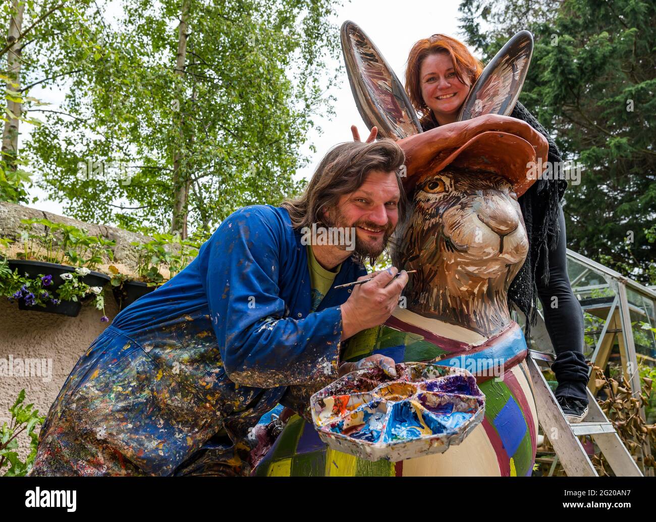 L'artiste Chris Rutterford peint une sculpture humoristique de lièvre géant dans son studio de plein air pour la piste d'art caritatif, avec son partenaire Lubi Lyken, Écosse, Royaume-Uni Banque D'Images
