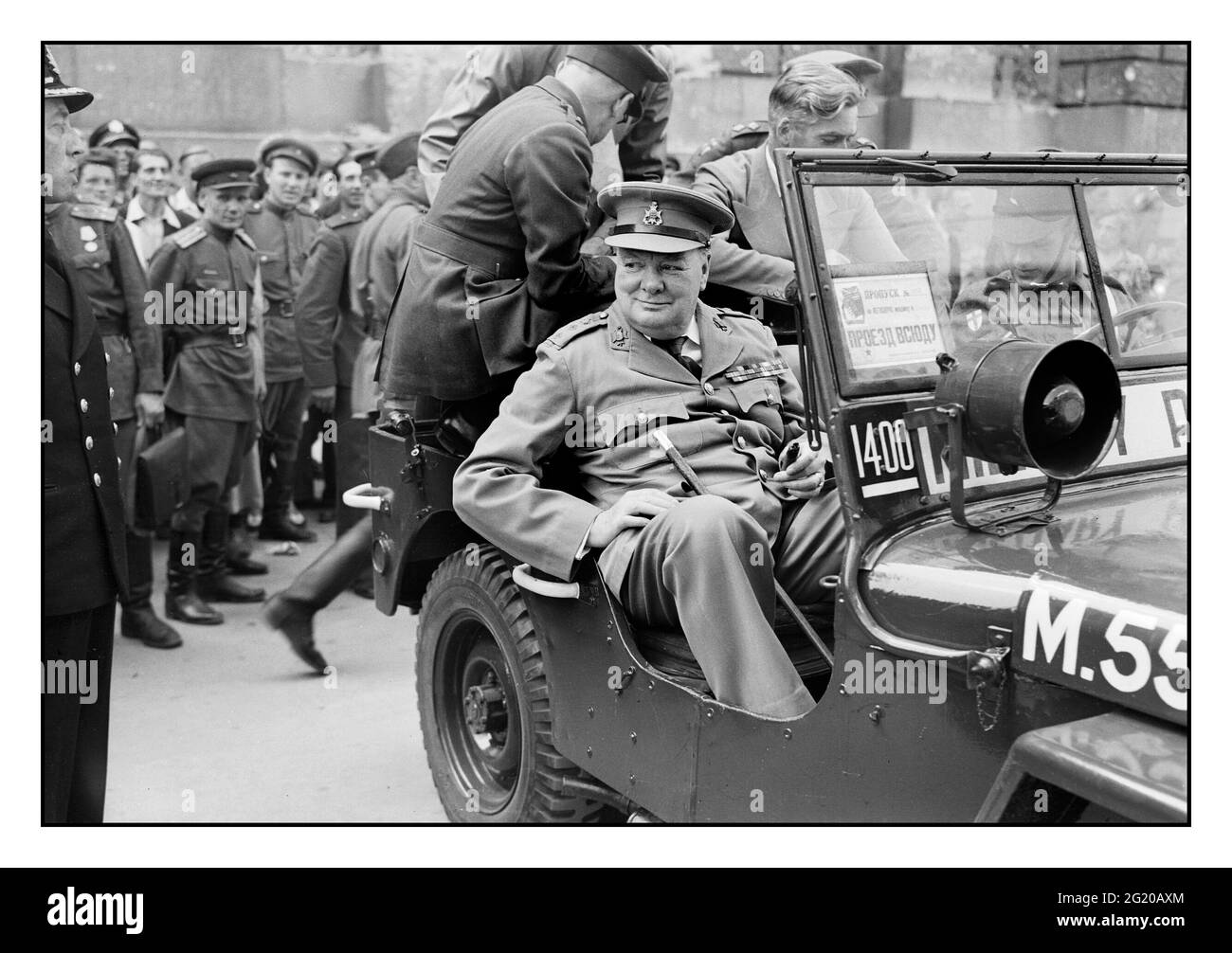 Winston Churchill à Berlin, juillet 1945, le premier ministre Winston Churchill est assis dans une jeep à l'extérieur du Reichstag avec des officiers russes derrière lui, lors d'une visite de la ville ruinée de Berlin, en Allemagne, le 16 juillet 1945 Banque D'Images