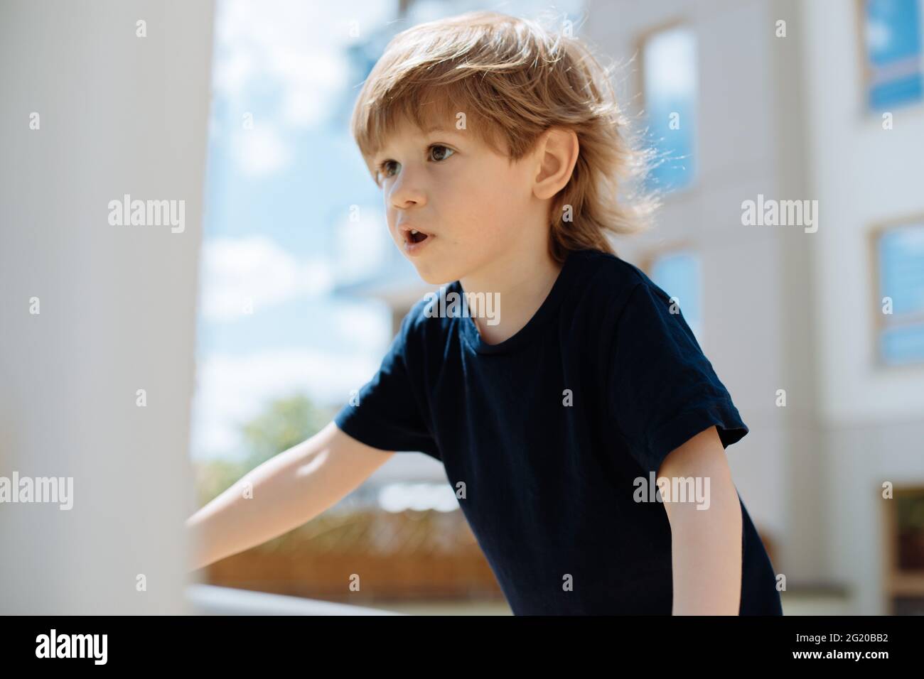 Gros plan d'un garçon de 3 ans qui exprime ses émotions tout en jouant sur un terrain de jeu en plein air Banque D'Images
