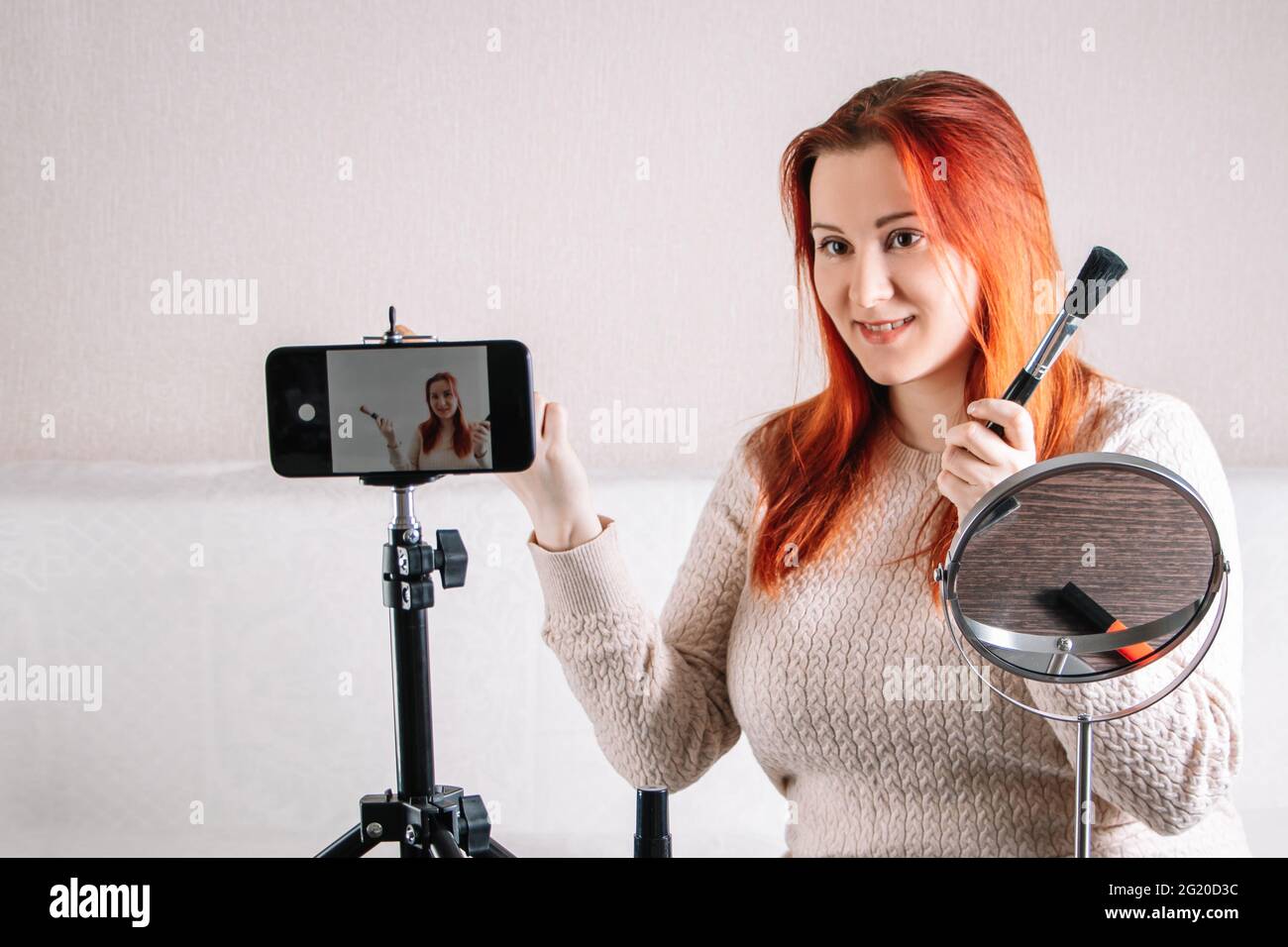 Flux en ligne des responsables d'influenceur de blogueur de beauté. Une jeune femme montre comment faire du maquillage et utiliser des cosmétiques. Espace de travail moderne, cours en ligne. Banque D'Images