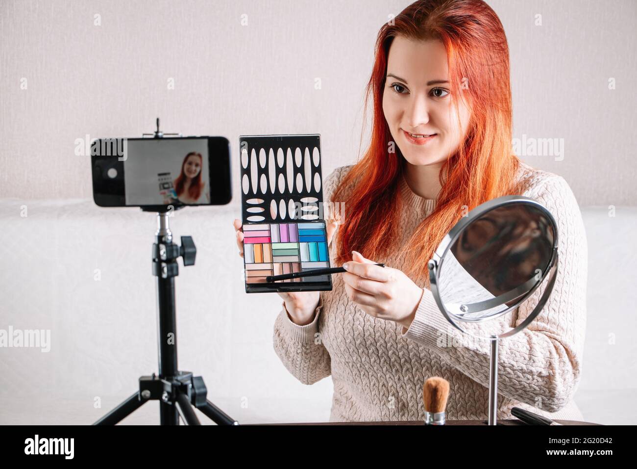 Jeune femme beauté blogger montre comment faire le maquillage et l'utilisation des cosmétiques. Influen?er enregistrer du contenu vidéo pour votre blog à la maison. Concept d'entreprise moderne Banque D'Images