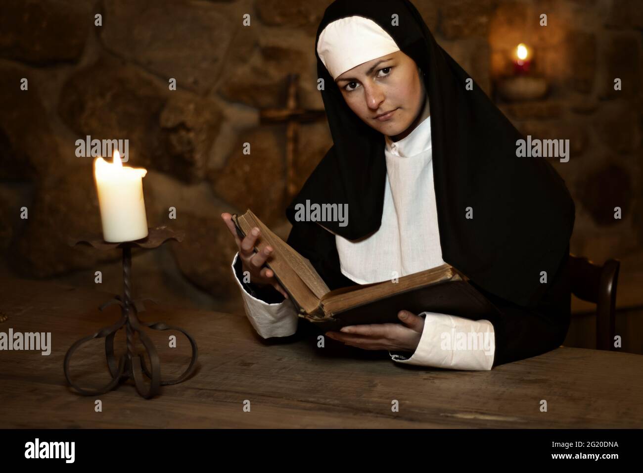 La jeune nonne étudie le vieux Biebel dans un vieux monastère Banque D'Images