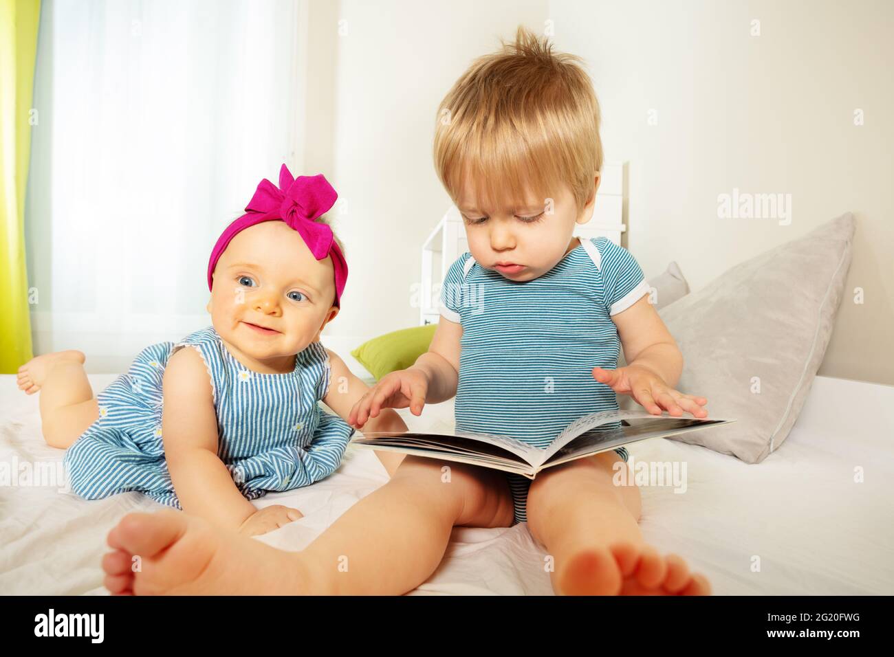 Deux petits enfants regardent et lisent le livre ensemble Banque D'Images