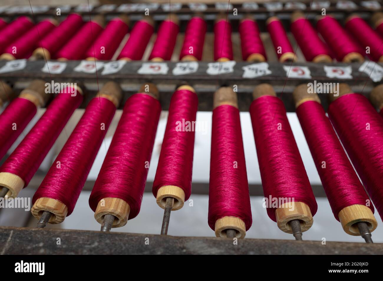 Atelier traditionnel de tisserands de Bevilacqua, les femmes travaillent sur des tisserres en bois vintage, produisant des textiles de luxe, à Venise depuis 1875 . Banque D'Images