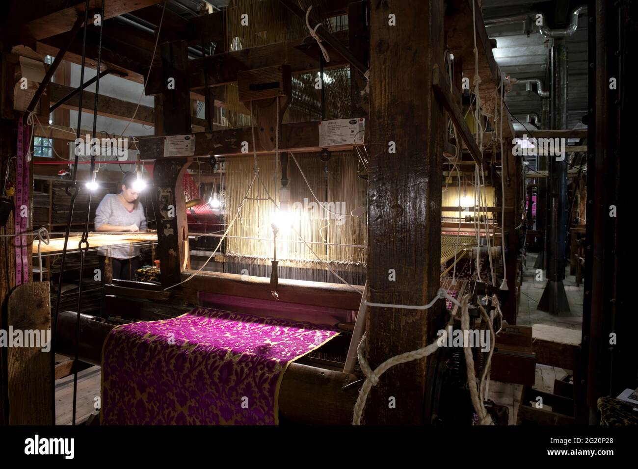 Atelier traditionnel de tisserands de Bevilacqua, les femmes travaillent sur des tisserres en bois vintage, produisant des textiles de luxe, à Venise depuis 1875 . Banque D'Images