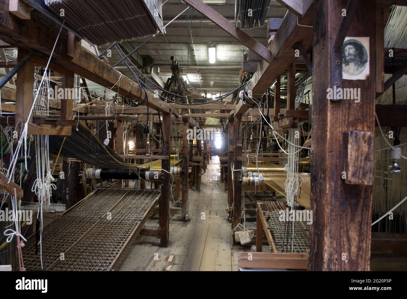 Atelier traditionnel de tisserands de Bevilacqua, les femmes travaillent sur des tisserres en bois vintage, produisant des textiles de luxe, à Venise depuis 1875 . Banque D'Images