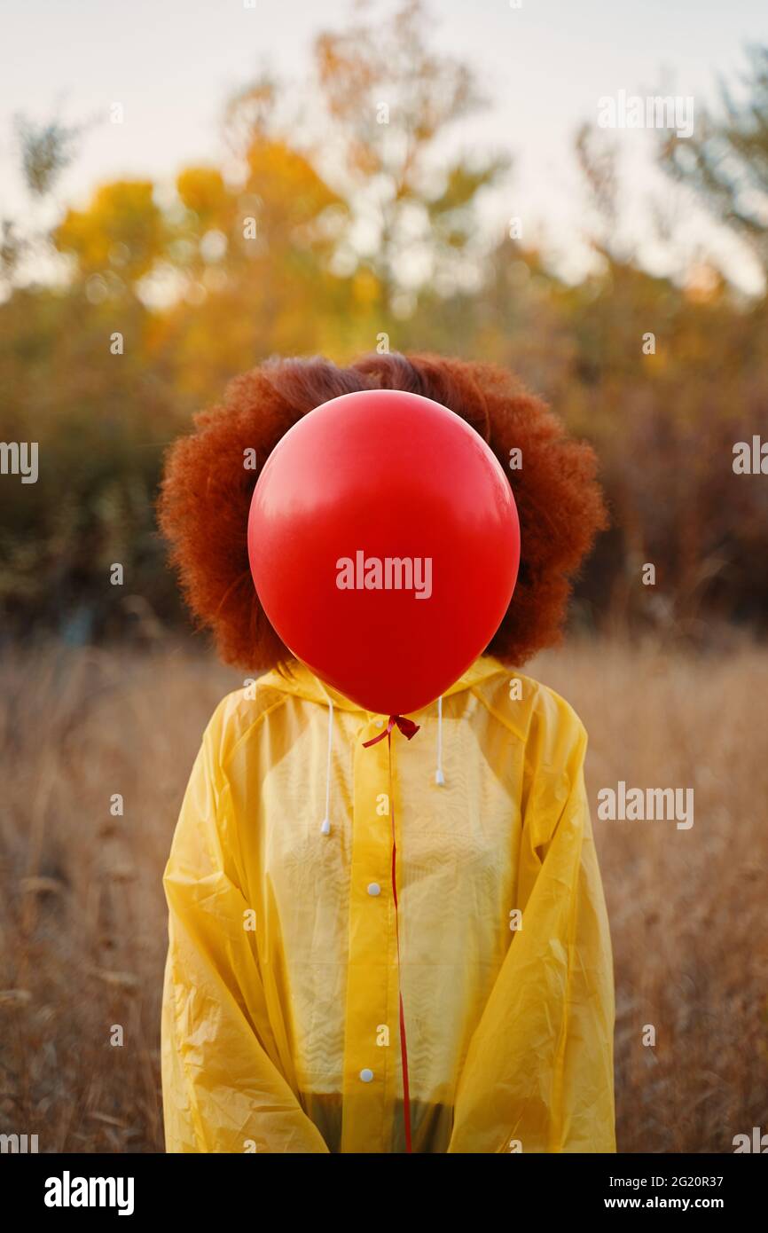 Portrait d'une fille souriante vêtue d'un imperméable posant. Une femme marche dans les bois sous un imperméable jaune, attendant la pluie. Banque D'Images