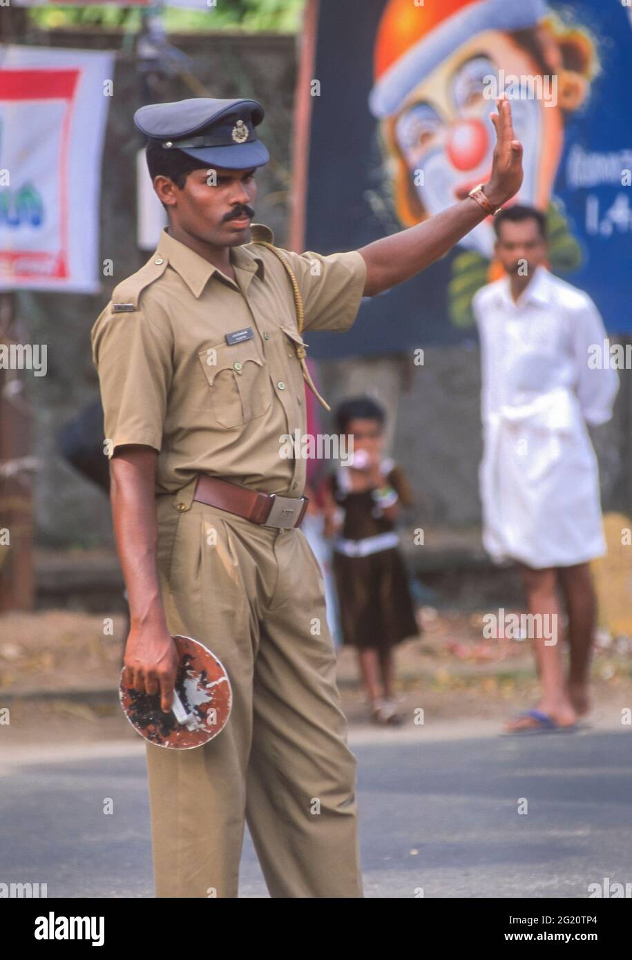 KERALA, INDE - le policier de la circulation dirige la circulation dans la rue. Banque D'Images