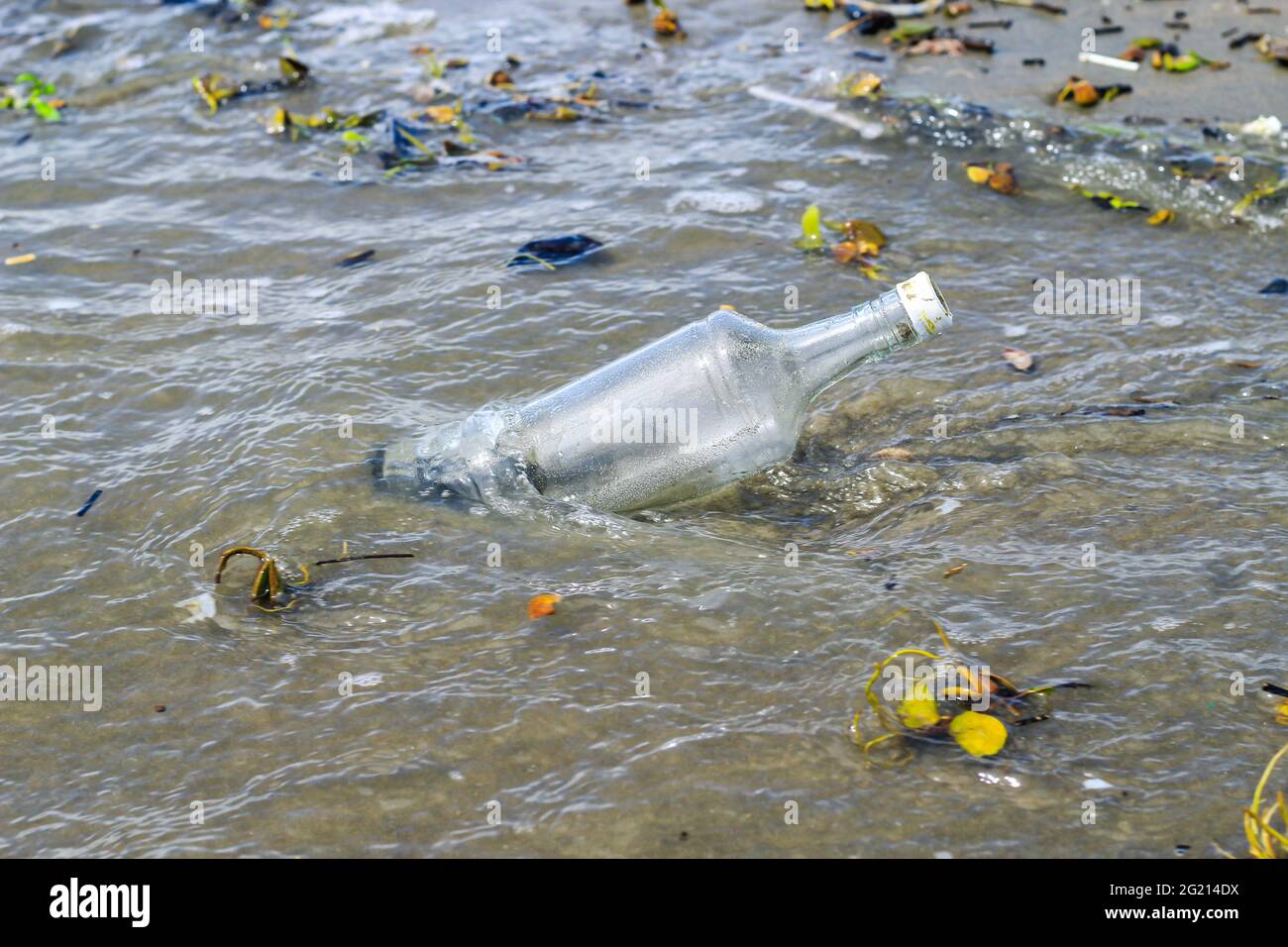 Pollution des bouteilles d'eau de verre dans l'océan (concept de l'environnement). Pollution de l'océan : déchets sur la plage. Banque D'Images