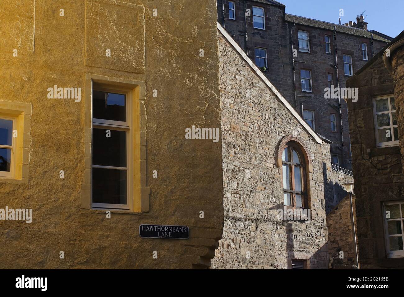 Couleurs et reflets de lumière douce soulignant la texture sur les murs des bâtiments historiques le long de la route de marche du ruisseau Banque D'Images
