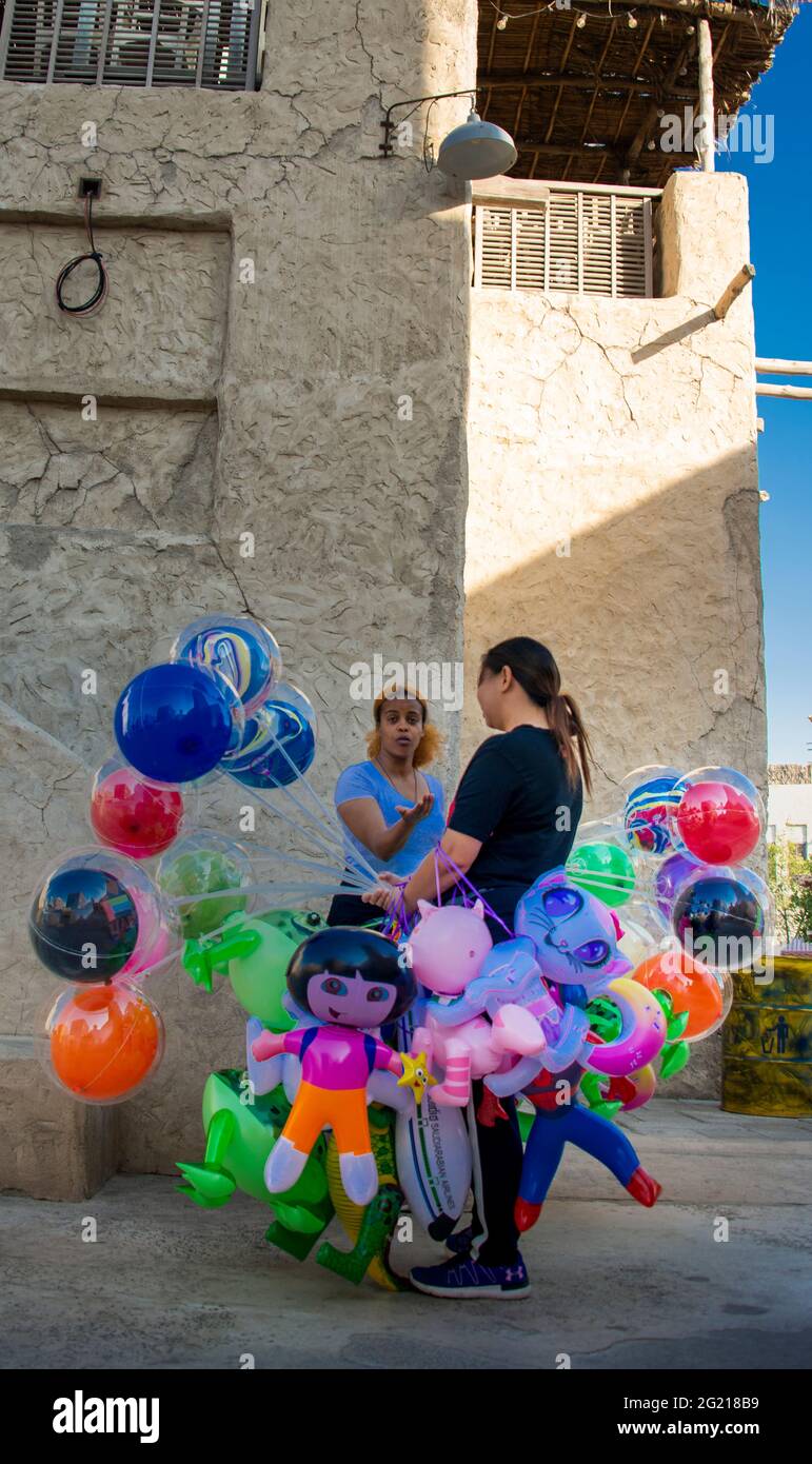 Un vendeur de rue vendant des ballons à un coin dans la zone touristique d'Al Seef à Dubaï. Banque D'Images