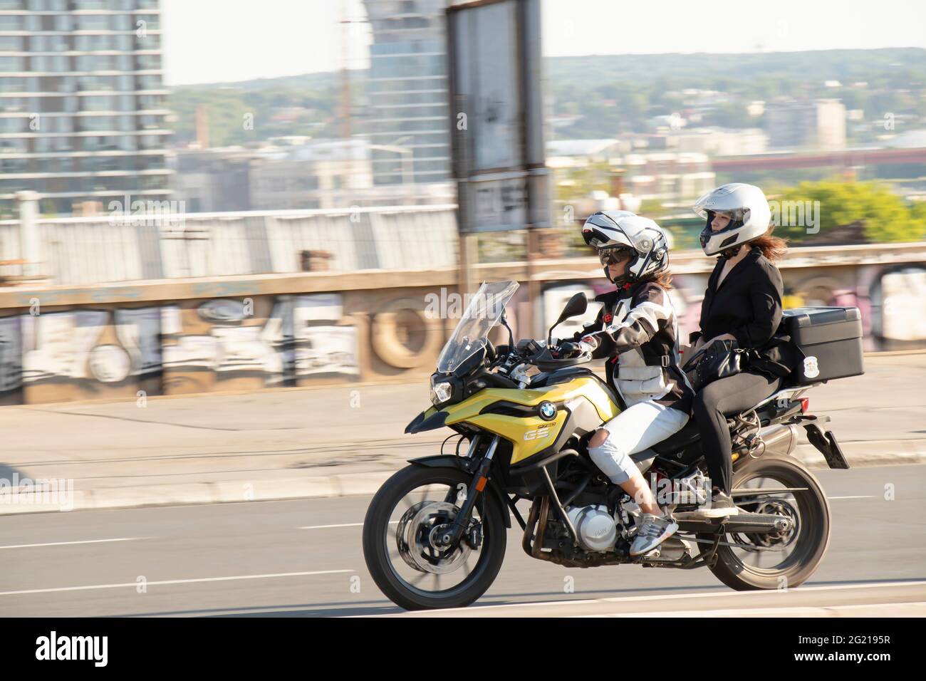 Belgrade, Serbie - 5 juin 2021 : jeune femme à moto avec une petite passager , dans la rue de la ville par beau temps Banque D'Images