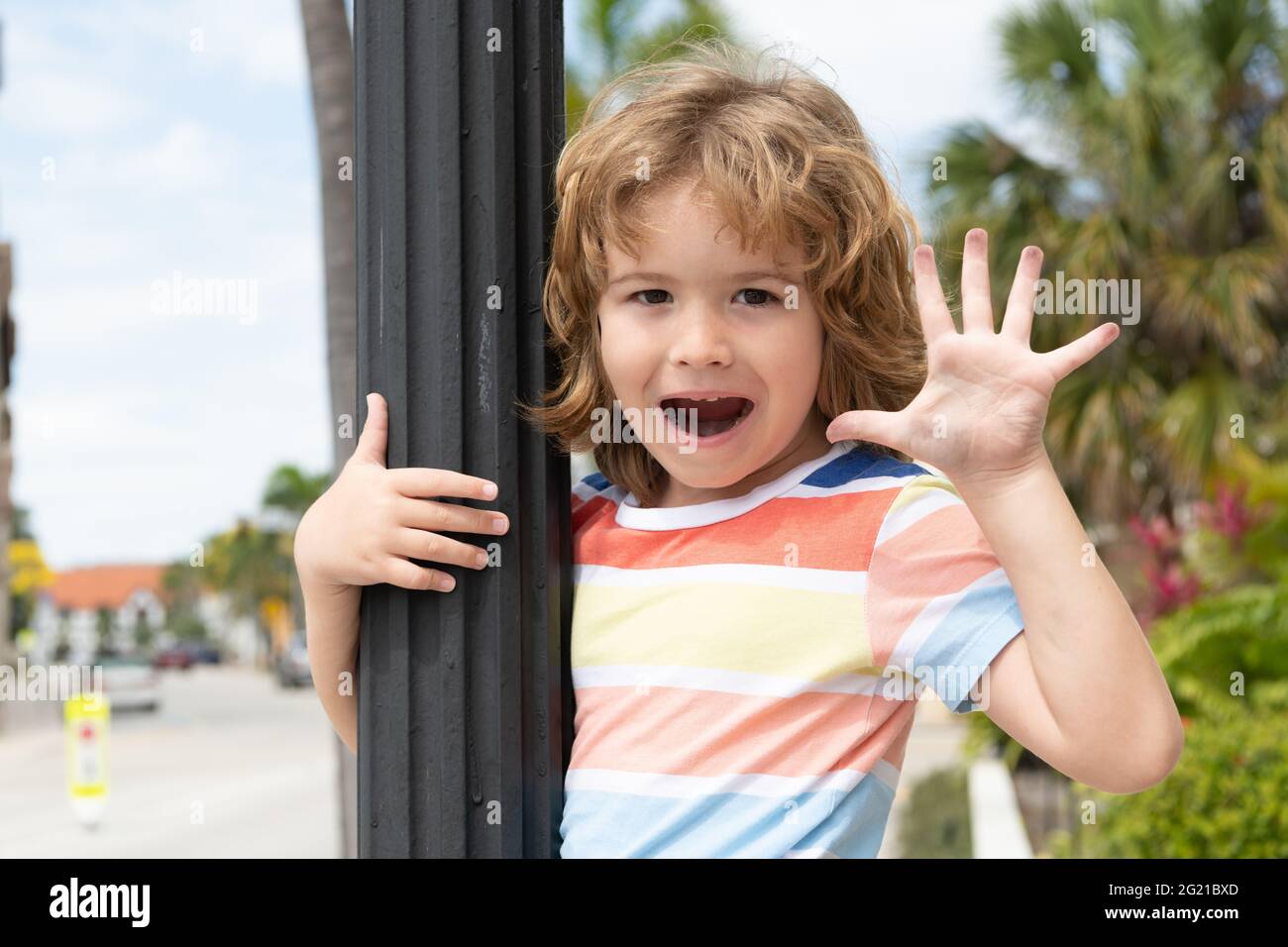 Joyeux garçon enfant main ouverte montrant cinq doigts en saluant l'été à l'extérieur, hi-cinq Banque D'Images