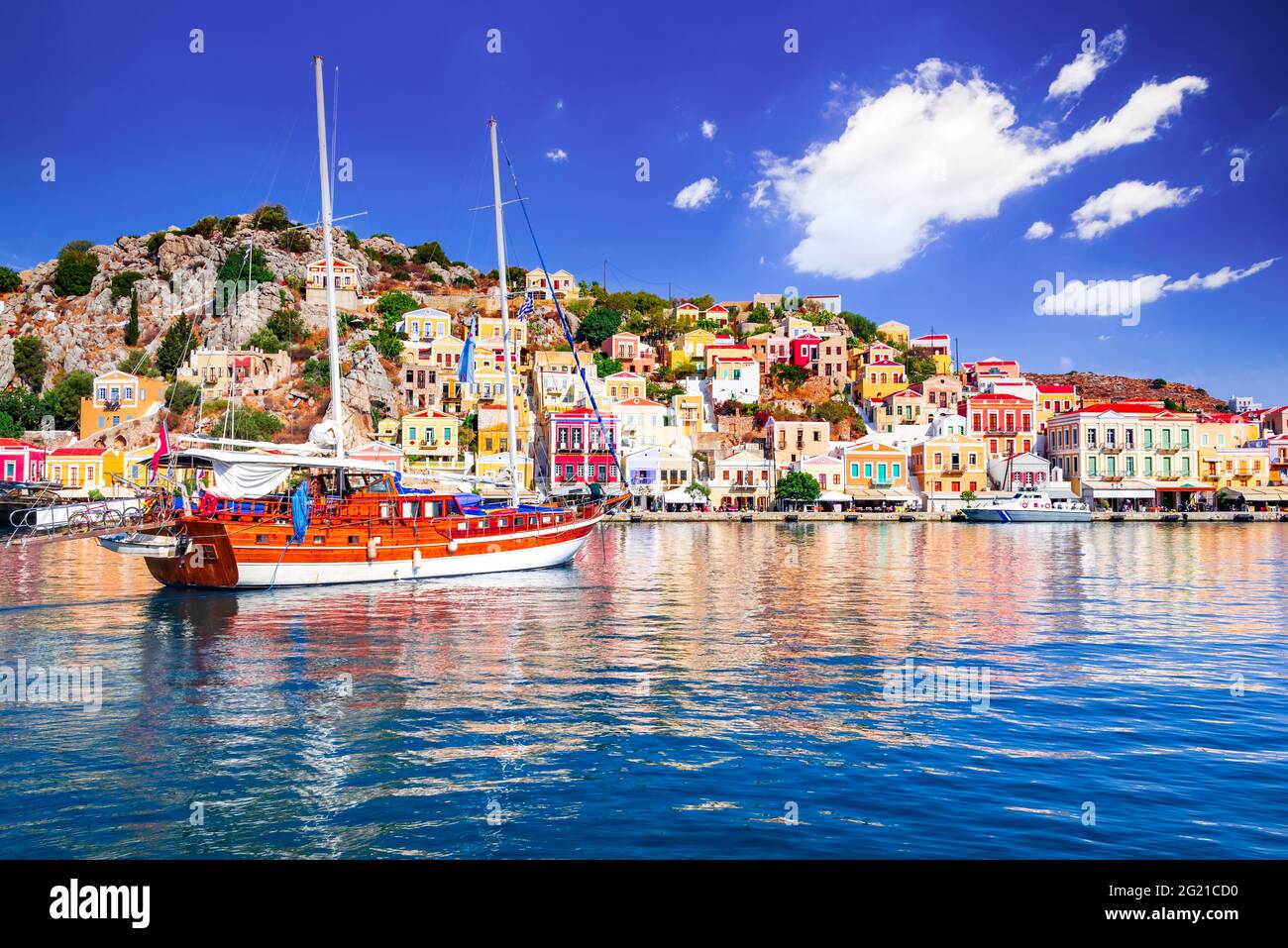 Île Symi, Grèce. Grèce îles vacances de Rhodos en mer Egée. Maisons néoclassiques colorées dans la baie de Symi. Arrière-plan du voyage de vacances. Banque D'Images