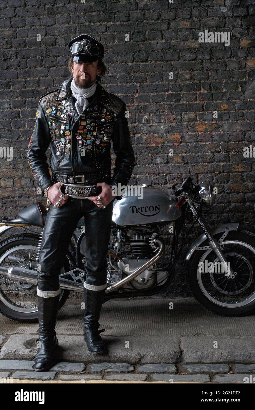 Rocker dans l'équipement de course de café portant une veste en cuir noir  couverte de clous, patches et badges classique de la moto britannique à  Londres, Royaume-Uni Photo Stock - Alamy
