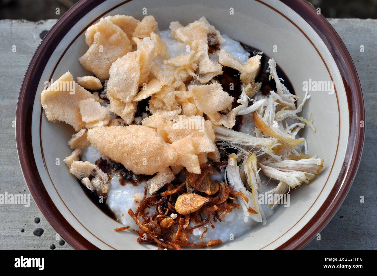 Porridge de poulet en Indonésie, accompagné de tranches de poulet et de craquelins Banque D'Images