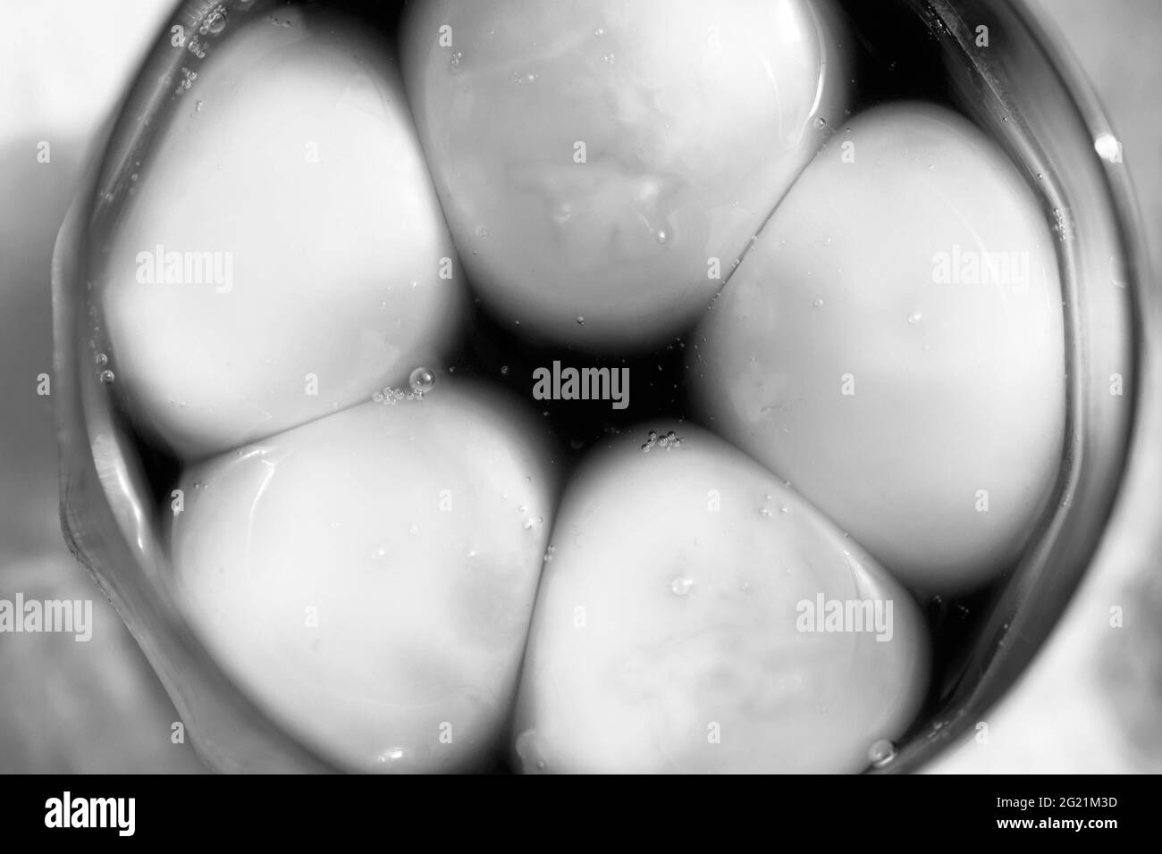 Jaunes d'œufs brillants dans une marinade japonaise dans un verre. Photo en noir et blanc. Banque D'Images
