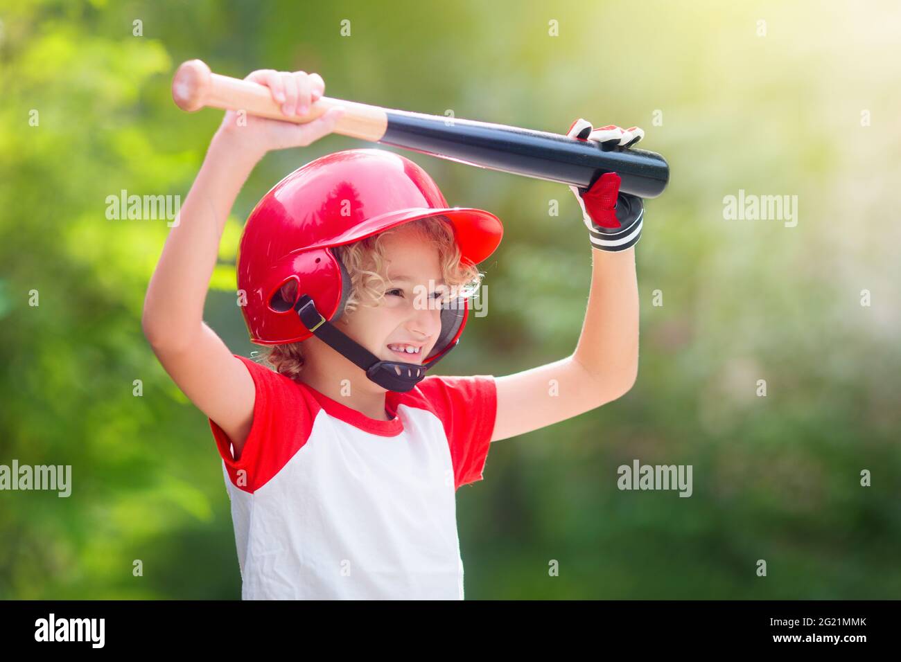 Les enfants jouent au baseball. Enfant avec chauve-souris et balle. Activités de plein air pour les enfants en bonne santé. Jeu de ballon d'équipe amusant pour garçon et fille. Jeune athlète sur le terrain de baseball. Banque D'Images