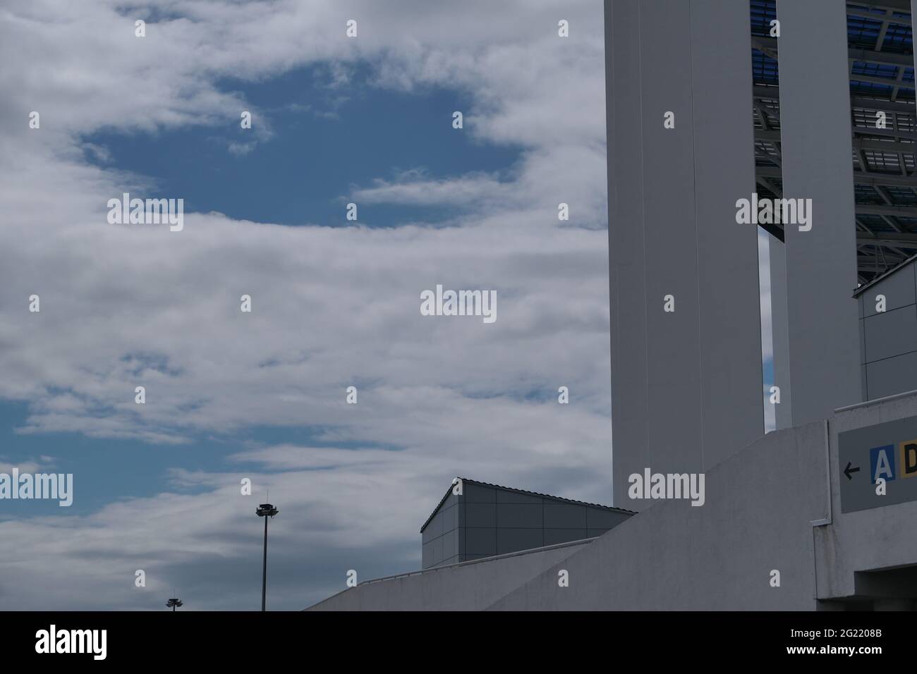 Un grand bâtiment avec des colonnes et un toit transparent contre le ciel bleu. Banque D'Images