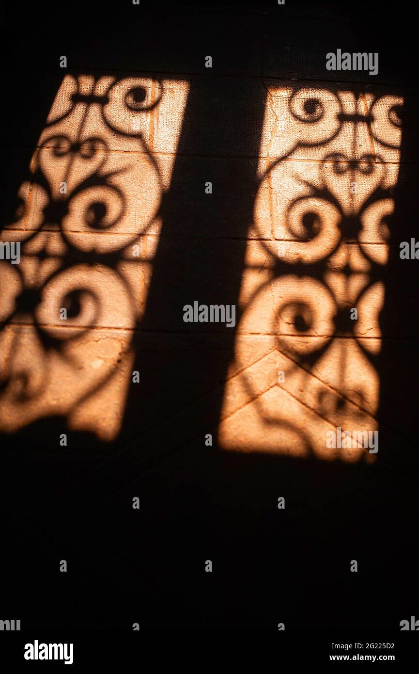 Ombres de la fenêtre ornée de métal sur sol en béton Banque D'Images