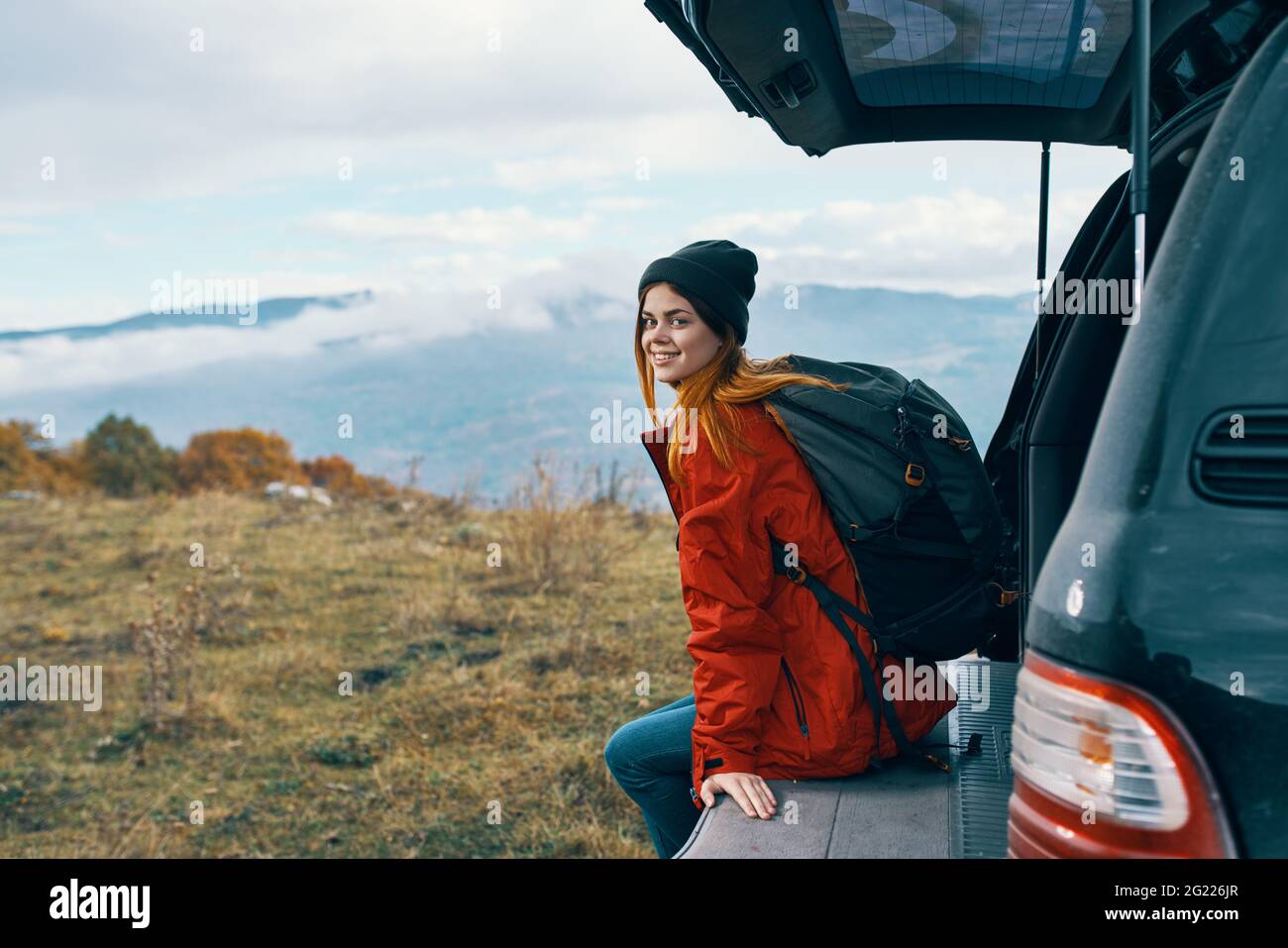 femme randonneur dans des vêtements chauds se reposant à l'automne dans les montagnes près de la voiture Banque D'Images