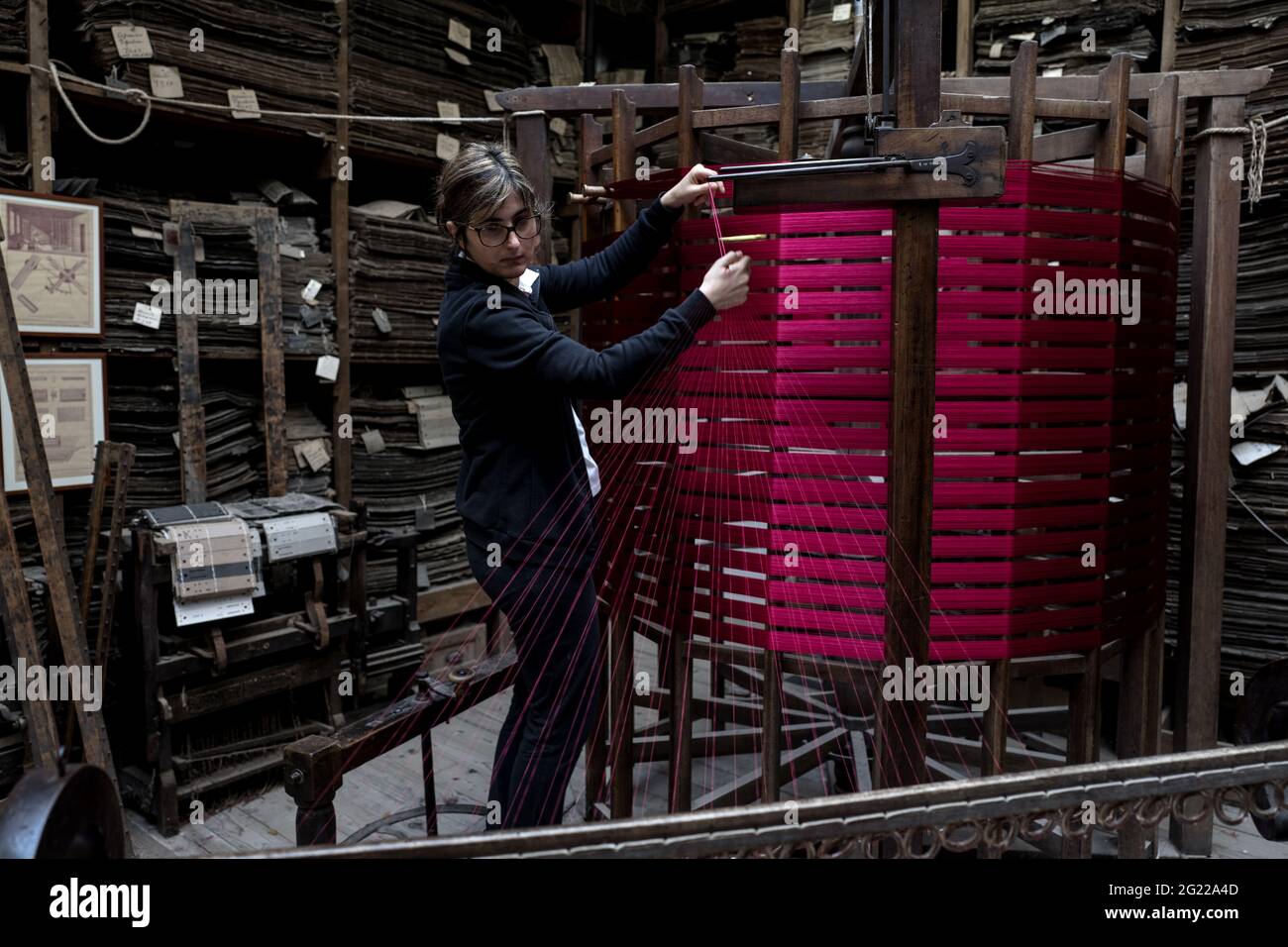 Une travailleuse au tissage fait à la main historique Luigi Bevilacqua, ils produisent des tissus fins pour le mobilier et la haute mode, à Venise, en Italie Banque D'Images