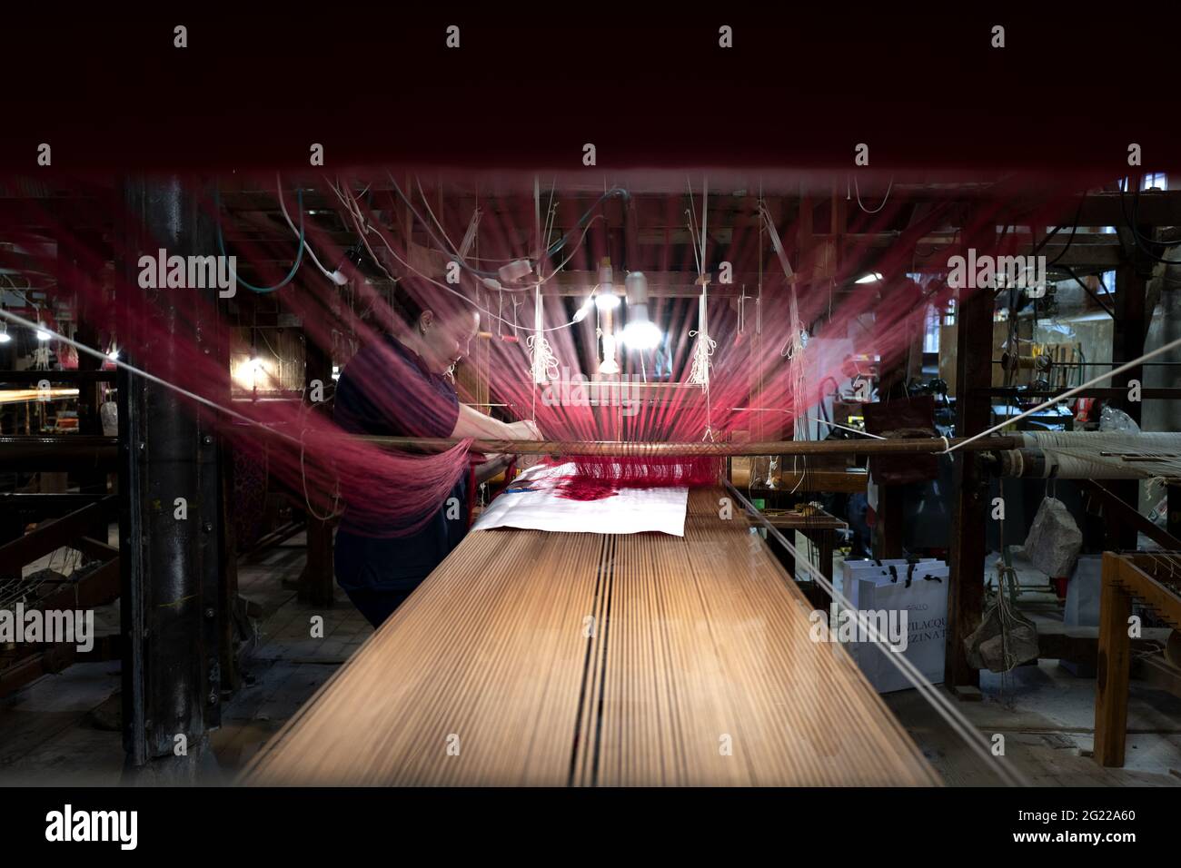 Une travailleuse au tissage fait à la main historique Luigi Bevilacqua, ils produisent des tissus fins pour le mobilier et la haute mode, à Venise, en Italie Banque D'Images