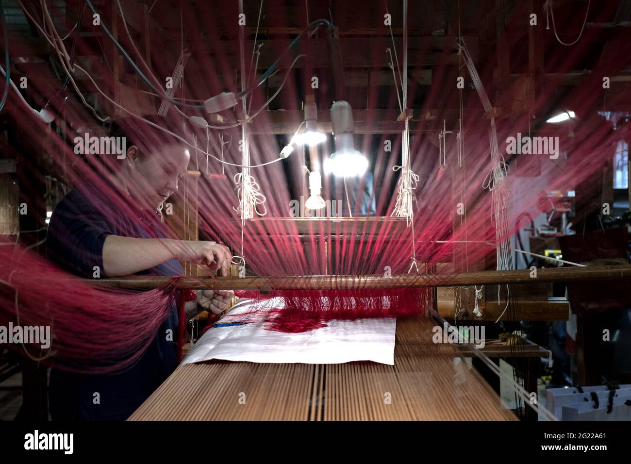Une travailleuse au tissage fait à la main historique Luigi Bevilacqua, ils produisent des tissus fins pour le mobilier et la haute mode, à Venise, en Italie Banque D'Images