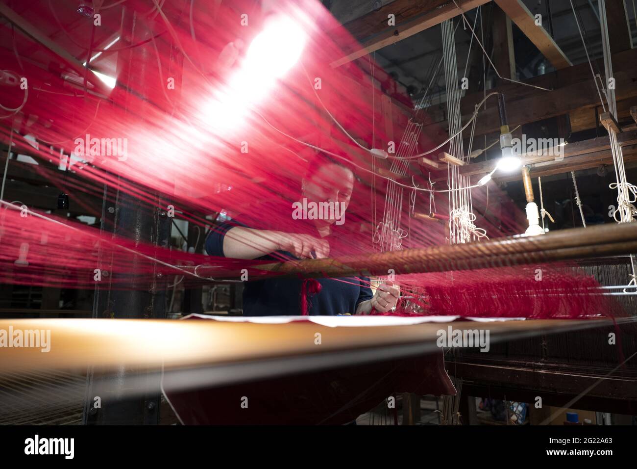 Une travailleuse au tissage fait à la main historique Luigi Bevilacqua, ils produisent des tissus fins pour le mobilier et la haute mode, à Venise, en Italie Banque D'Images