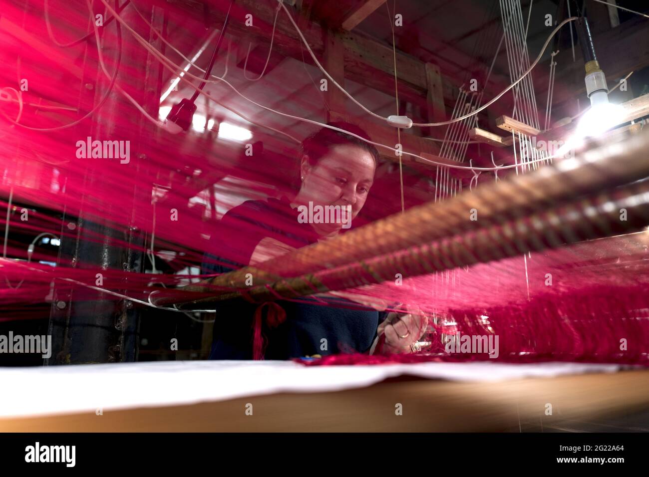Une travailleuse au tissage fait à la main historique Luigi Bevilacqua, ils produisent des tissus fins pour le mobilier et la haute mode, à Venise, en Italie Banque D'Images