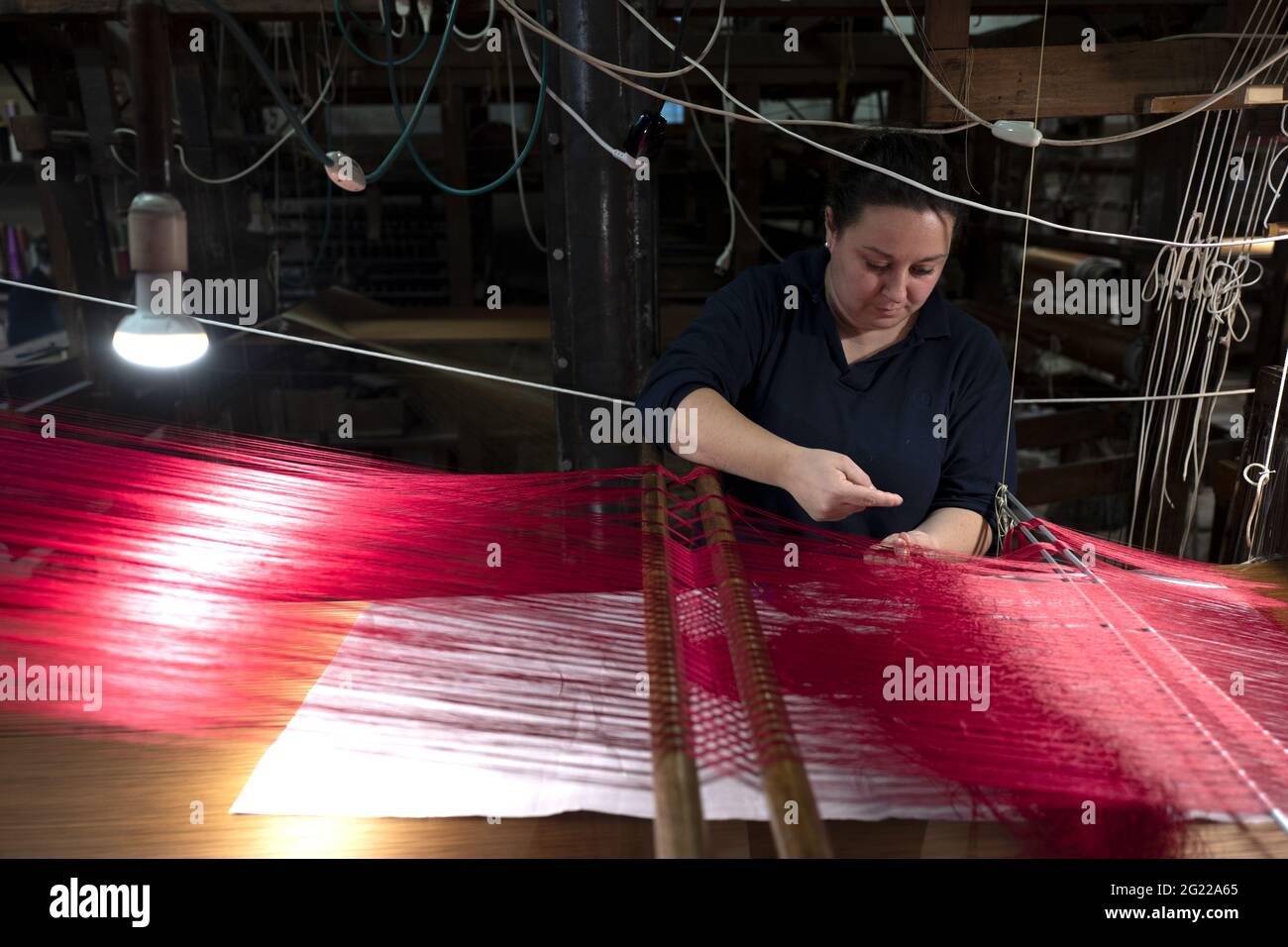 Une travailleuse au tissage fait à la main historique Luigi Bevilacqua, ils produisent des tissus fins pour le mobilier et la haute mode, à Venise, en Italie Banque D'Images